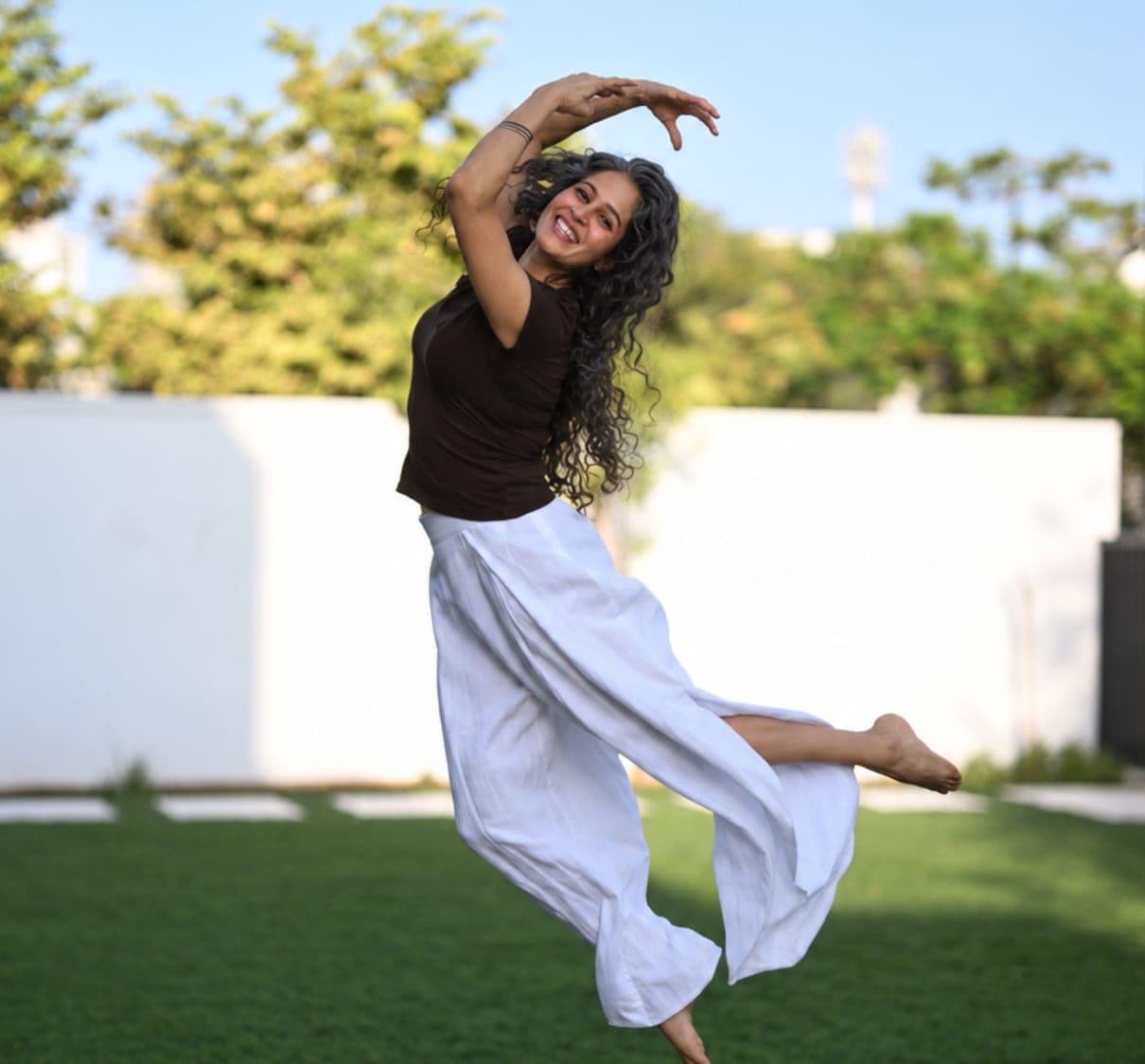 Dr. Sumaiya Menon dancing on a lawn